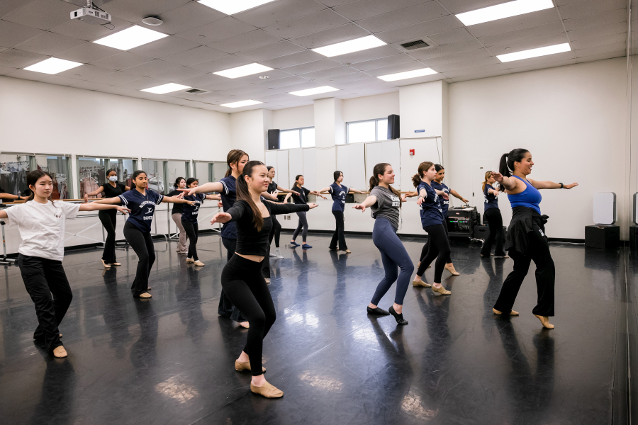 Intern in front of dance students demonstrating a dance move