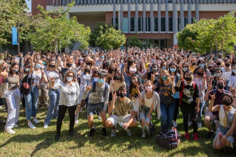 Hundreds of students stand in the meditation garden in front of the Contemporary Arts Center.