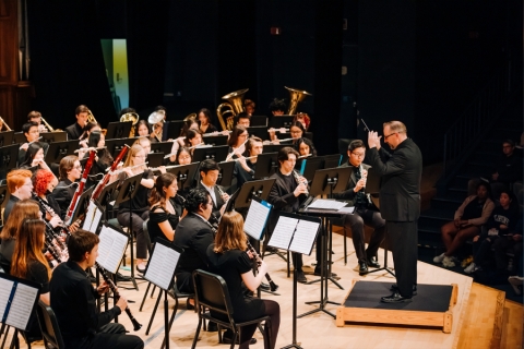 Wind ensemble members playing on stage