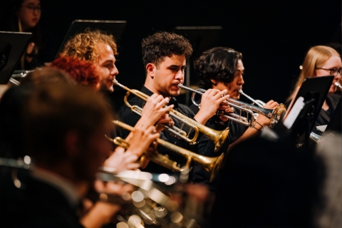 Close-up of wind ensemble members mid-performance